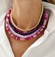 A bright mix of pink, purple, and gold tone beaded Palermo necklaces.